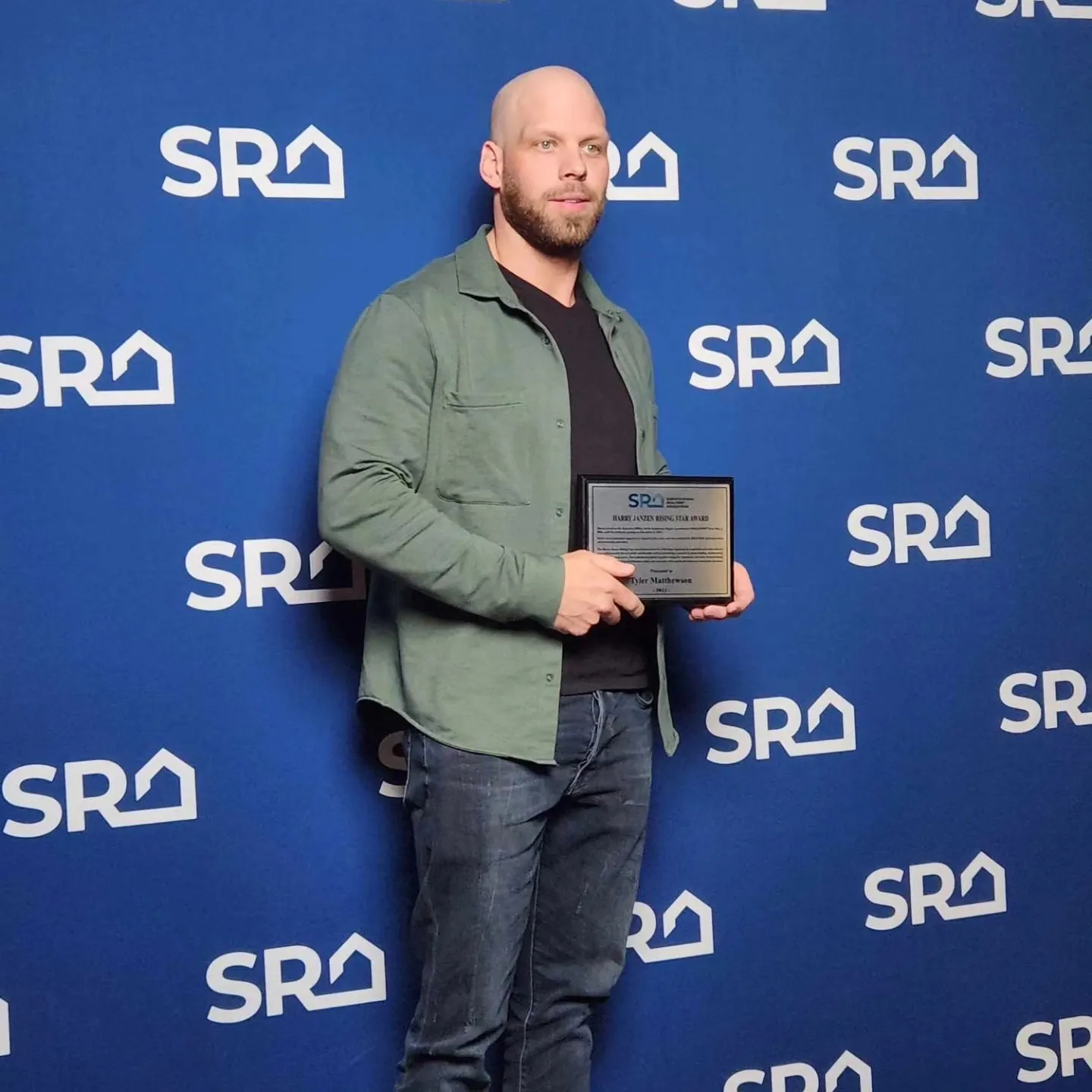 Tyler Matthewson holding a Saskatchewan Realtors Association award